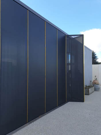 Folding steel privacy screen on the exterior of a house